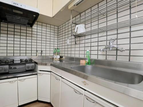 a kitchen with a sink and a stove at サムティ扇町 in Osaka