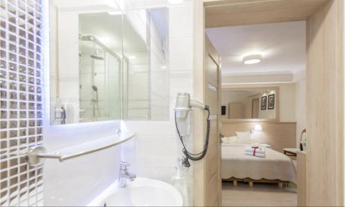 a bathroom with a shower and a sink and a bed at Villa Anna - Noclegi Rooms - FREE parking, taras, 1500m do Starówki in Gdańsk