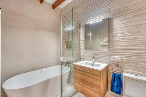 a bathroom with a tub and a sink and a mirror at Ideal Property Mallorca - Corro Sant Jaume in Alcudia