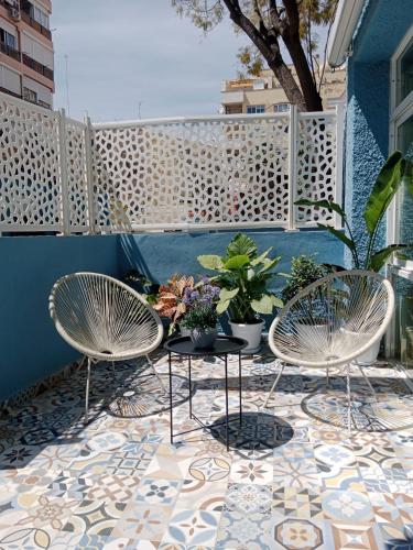 a patio with two chairs and a table with plants at Apartamentos El Velero in Torremolinos