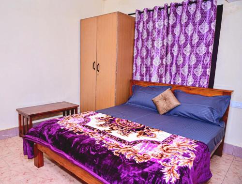 a bedroom with a purple bed with a canopy at coorg mantion homestay in Madikeri