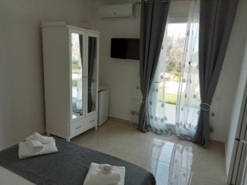 a bedroom with a bed and a large window at Villa Bello camere in Giurdignano