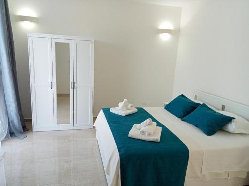 a bedroom with a large bed with towels on it at Villa Bello camere in Giurdignano