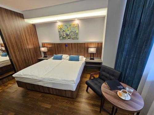 ein Hotelzimmer mit einem Bett und einem Tisch in der Unterkunft Atelier Hotel in Ljubljana