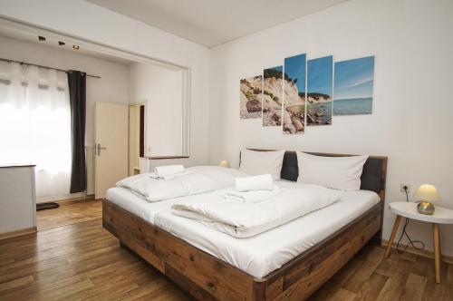 a bedroom with a large bed with white sheets at Ferienhus Baabe Ferienwohnung 01 mit gratis Nutzung vom AHOI Erlebnisbad und Sauna in Sellin in Baabe