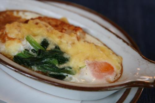 a bowl of food with broccoli and cheese on a plate at Kunugi Relaxation with 4 modern rooms in Hakuba