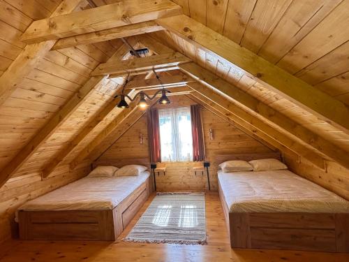 two beds in the attic of a log cabin at Cottage retreat- Skadar Lake in Virpazar
