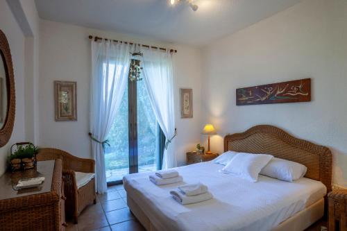 a bedroom with a bed with towels on it at Magnolia bliss Calm & Cozy Villa, Sani in Sani Beach