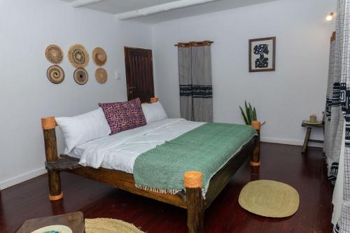 a bedroom with a bed with a green blanket on it at Kitunduni Lodge in Arusha