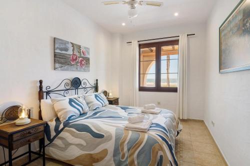 a bedroom with a bed and a table and a window at Matalascañas Primera Línea de Playa in Matalascañas