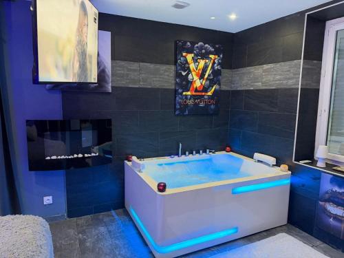 a bathroom with a tub with a painting on the wall at Maison cocooning , avec double jacuzzi et piscine in La Machine