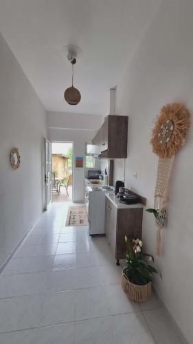 a kitchen with white tile floors and a kitchen with a stove at Glossy Messinian Escape - Cozy Yard Apartment in Filiatra