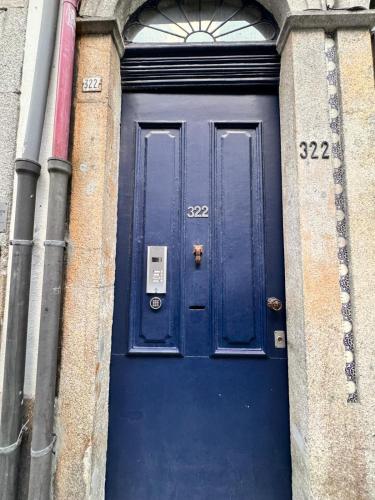 a blue door in a brick building with numbers on it at Guest World in Porto