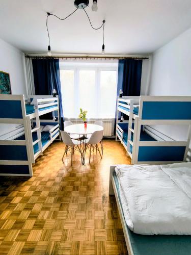 a bedroom with two bunk beds and a table and chairs at Luna Rooms Oświęcim in Oświęcim