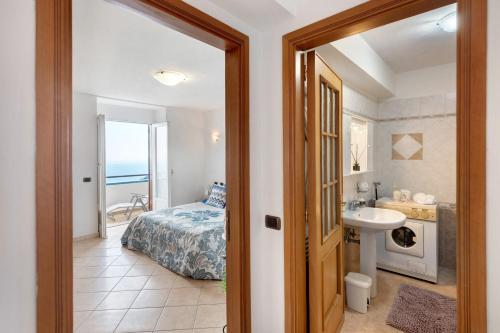 a bathroom with a bedroom with a bed and a sink at Le Terrazze Di Serafina in Furore