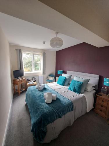 a bedroom with a large bed with blue pillows at The Ship Inn in Bardsea