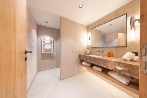 a bathroom with a large sink and a mirror at Hotel Rosatsch Residence in Pontresina
