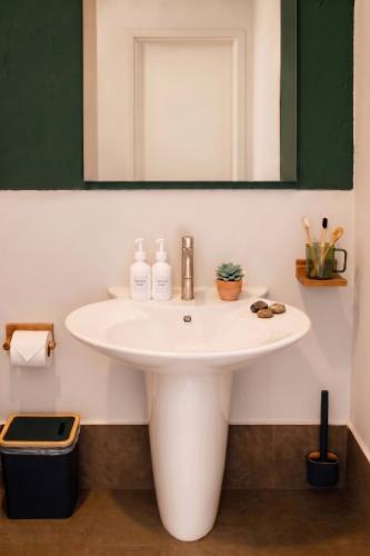 a bathroom with a white sink and a mirror at CenterPoint Thong Sala in Thong Sala