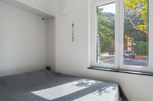 a bedroom with a bed and a window at Bilo Cinema in Bonassola
