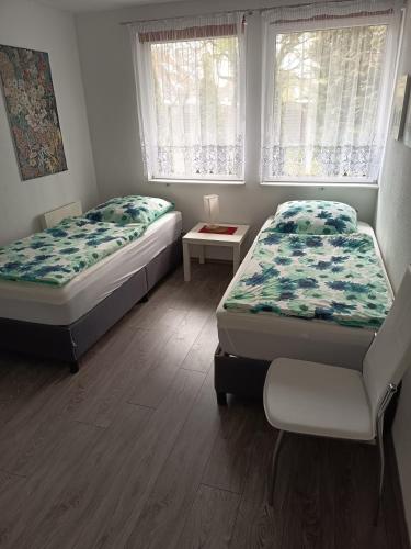 two beds in a room with two windows at Ferienhaus Gregor in Birkenwerder