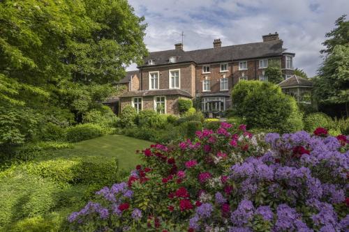 a large house with a garden with flowers at Best Western Valley Hotel in Ironbridge