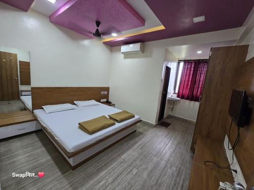 a bedroom with a bed and a purple ceiling at Hotel Shreejay Lodging in Mahād