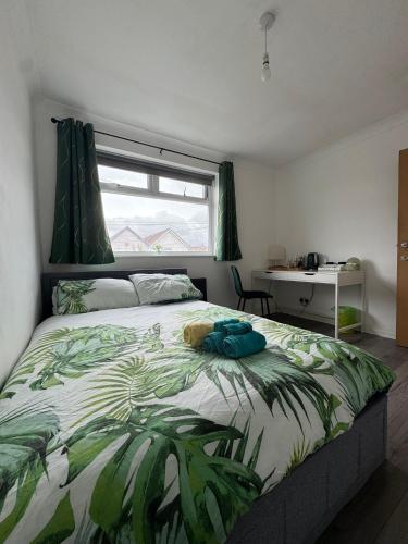 a bedroom with a bed with a green leafy comforter at Victoria Park in Bristol