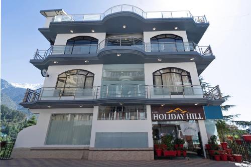 a large building with balconies on top of it at Treebo Holiday Hill in Dharmsāla