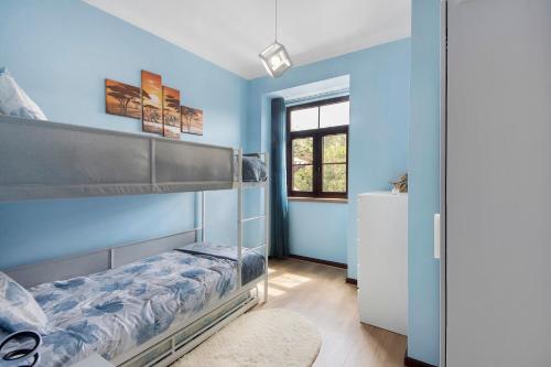 a bedroom with blue walls and a bunk bed at Casa da Ponte in Lombinha