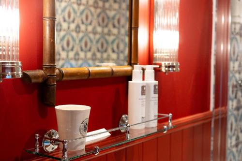a bathroom with a mirror and a glass shelf at The King's Arms in Hawkshead