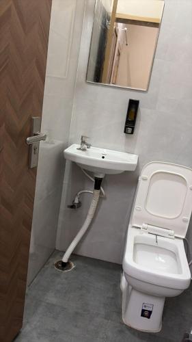 a bathroom with a sink and a toilet and a mirror at Moon Stays Newly Build I Couple Friendly I Panipat in Pānīpat
