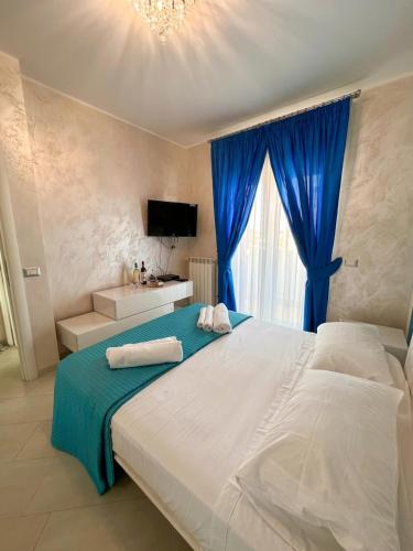 a bedroom with a large bed with a blue curtain at Fiorucci Apartments - Veronica's House Fiumicino in Focene