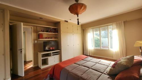 a bedroom with a bed and a tv and a window at Casona en pleno Centro in Tandil