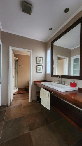 a bathroom with a sink and a large mirror at Casona en pleno Centro in Tandil