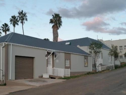 a house with a garage and a palm tree at Mayors Rest on 44 in Uniondale