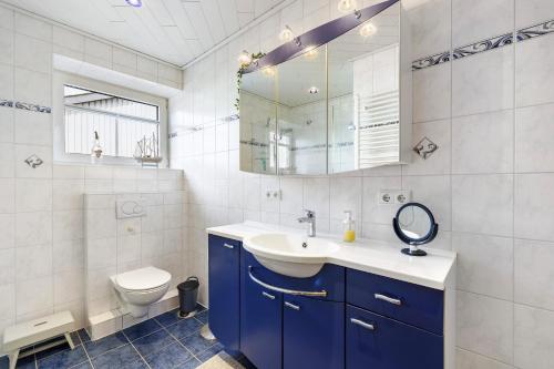 a bathroom with a sink and a toilet and a mirror at Pure Relaxation in Heiligenhafen