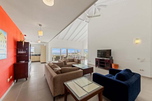 a living room with two couches and a tv at Blue Horizon Penthouse in Dorp Sint Michiel