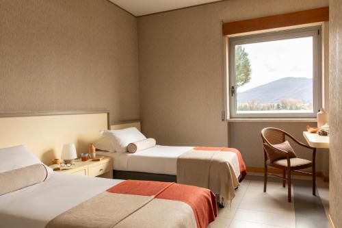 a hotel room with two beds and a window at Hotel Al Sant'Andrea in Sarzana