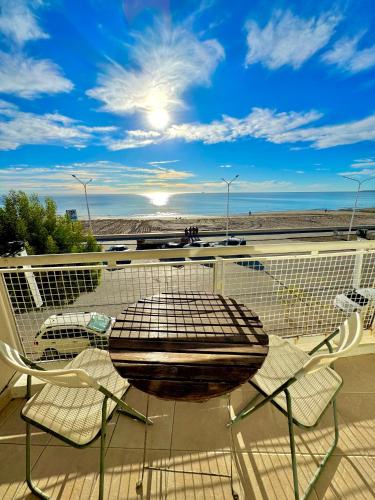 Ein Tisch und Stühle auf einem Balkon mit Blick auf den Strand in der Unterkunft Boulevard 10 - Dúplex frente al mar con balcón y vista panorámica in Puerto Madryn