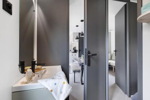 a bathroom with a sink and a mirror at Mobilehome riviera avec terrasse 48 in Saint-Gervais