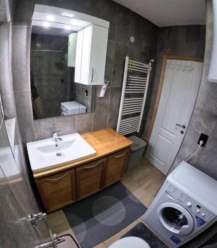 a bathroom with a sink and a toilet and a mirror at Lavanda Lux in Drvar