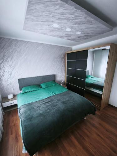 a bedroom with a large bed and a mirror at Lavanda Lux in Drvar