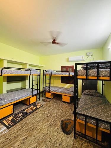 a room with four bunk beds in a room at A2KD Stay - Achyutam Keshavam Krishna Damodaram in Tiruvannāmalai