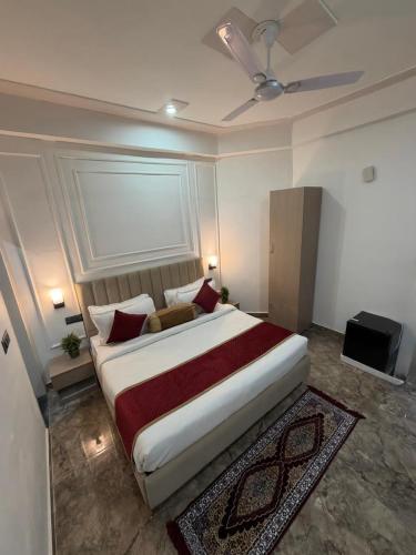 a bedroom with a large white bed with red pillows at A One Residency in Bahora