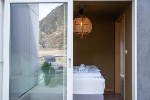 a room with a bed and a glass door at Villa Lofoten balcony view in Ballstad