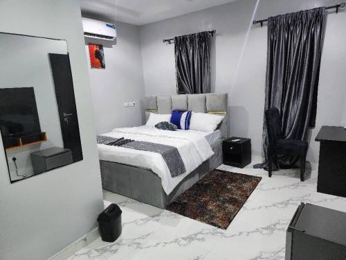 ein Schlafzimmer mit Bett, Spiegel und Fernseher in der Unterkunft The Bubbles Hotel in Akobo