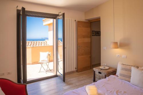 a room with a bed and a view of the ocean at Fantastica Villa con piscina e vista mare in Alghero
