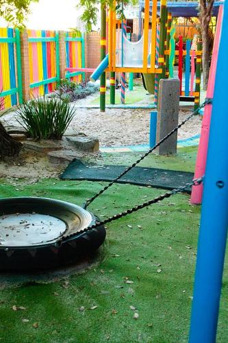 a playground with a tire on the grass at Perth City Apartment Hotel in Perth