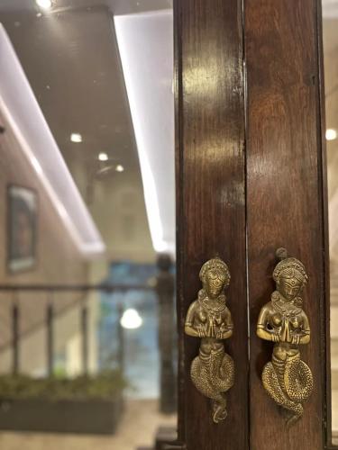 a wooden door with two gold knobs on it at Hotel Yadu Residency in Meerut