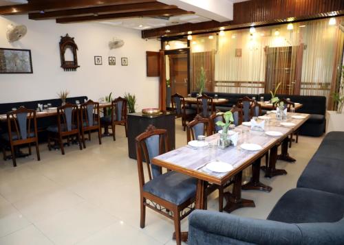 a dining room with a long table and chairs at Hotel Yadu Residency in Meerut
